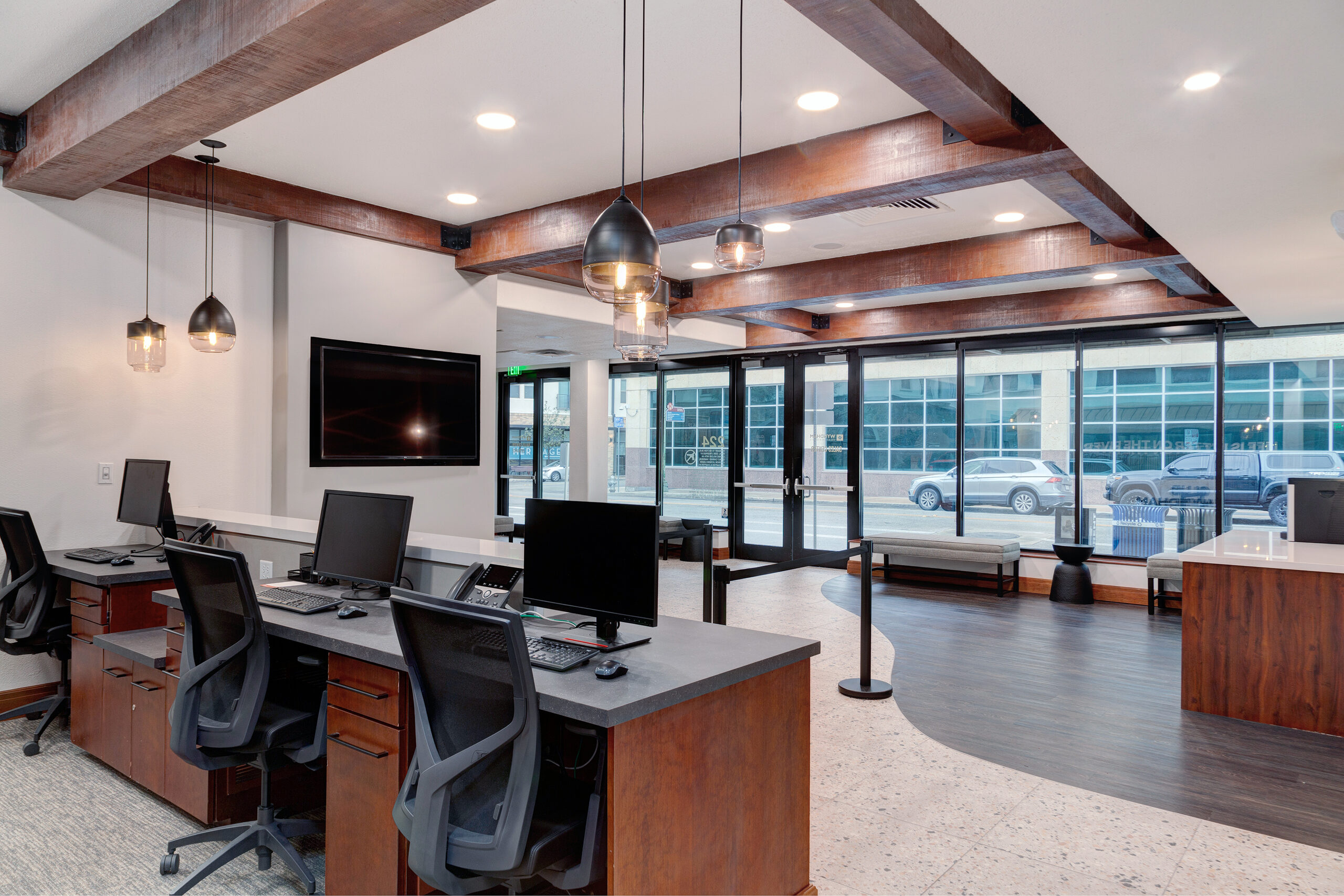 Open workspace at the La Cascada sales centre with exposed beams and street-facing glazing