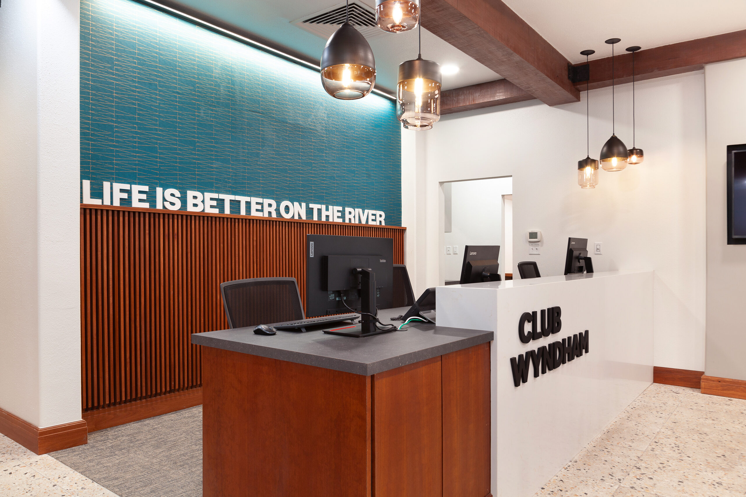 Club Wyndham reception desk at La Cascada beneath a timber slat feature wall