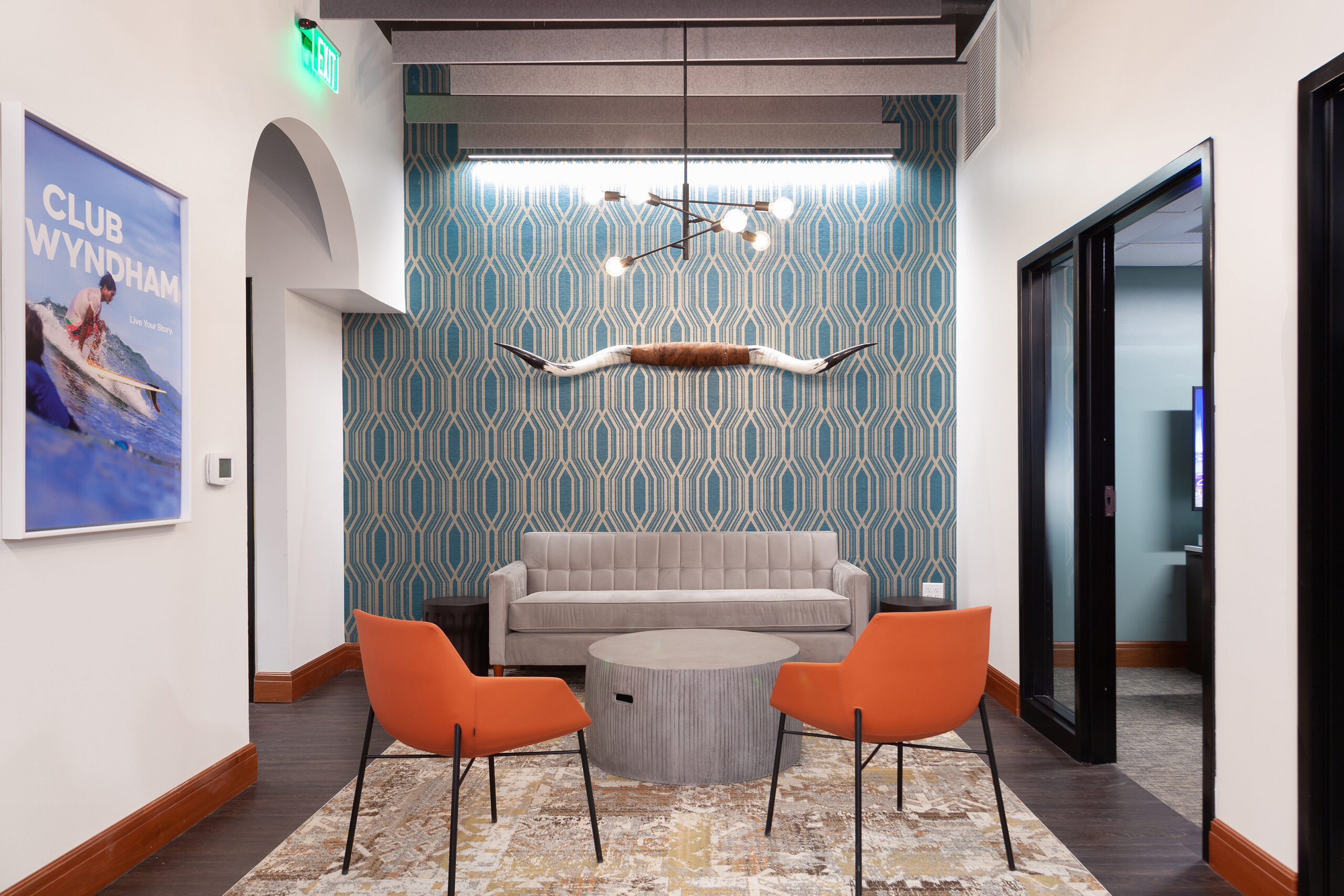 Lounge area at the La Cascada sales centre with patterned wallcovering and orange seating