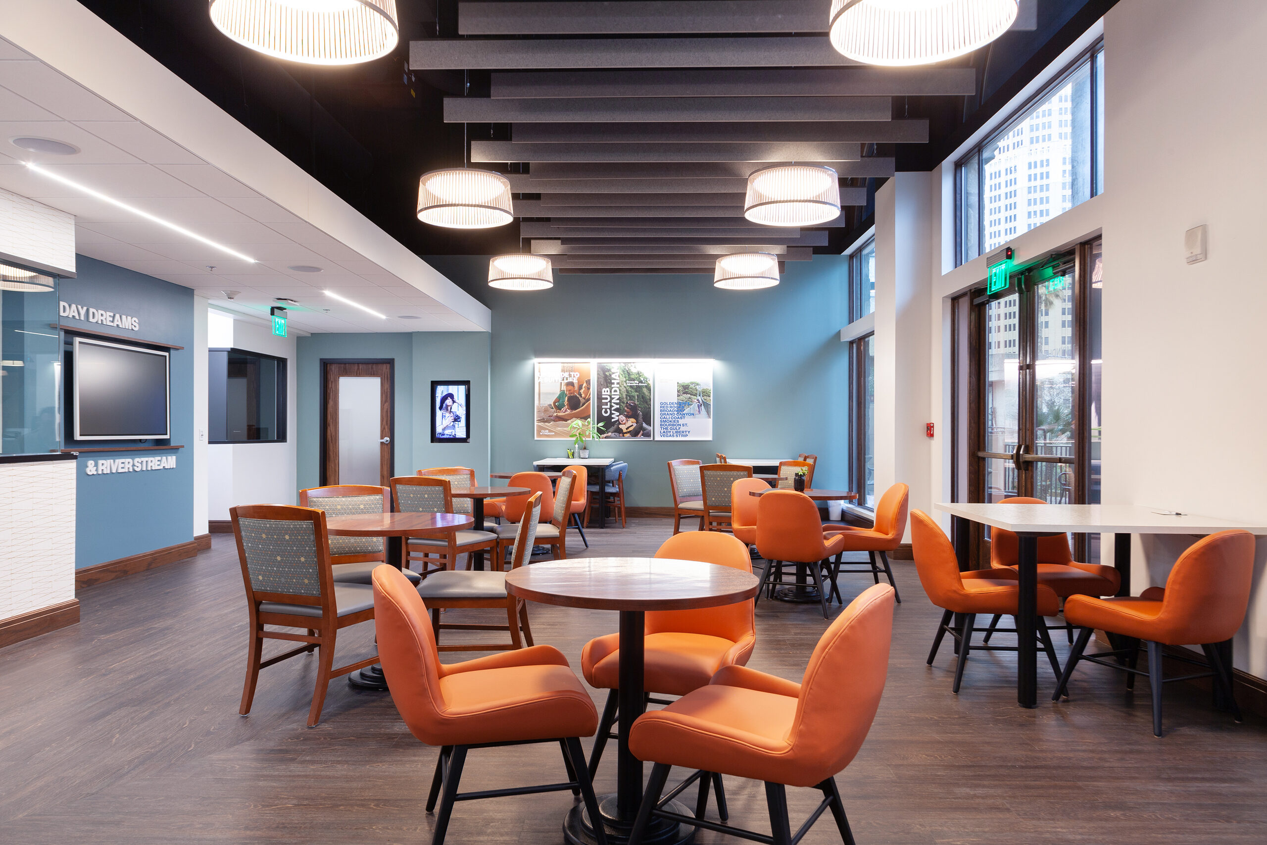 Cafe seating at the La Cascada sales centre with round tables and pendant lighting