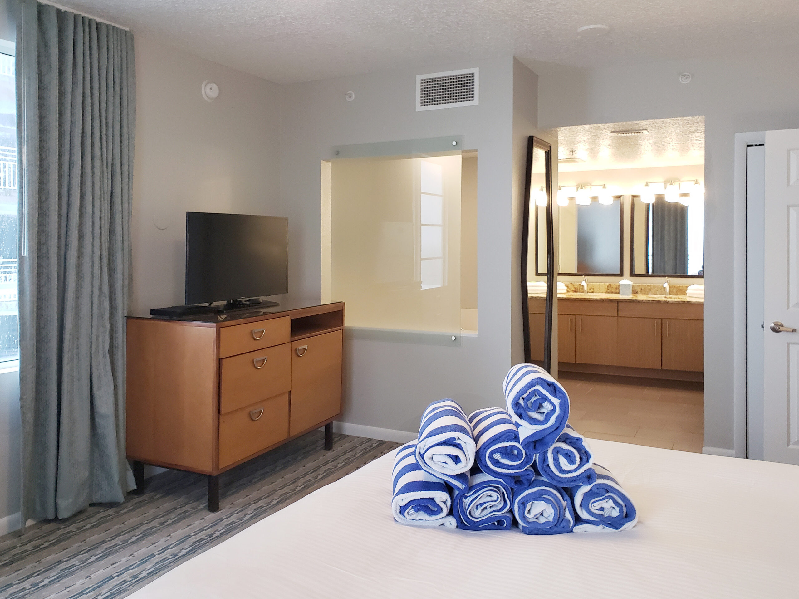 Renovated guestroom at Wyndham Ocean Walk with media console and vanity area
