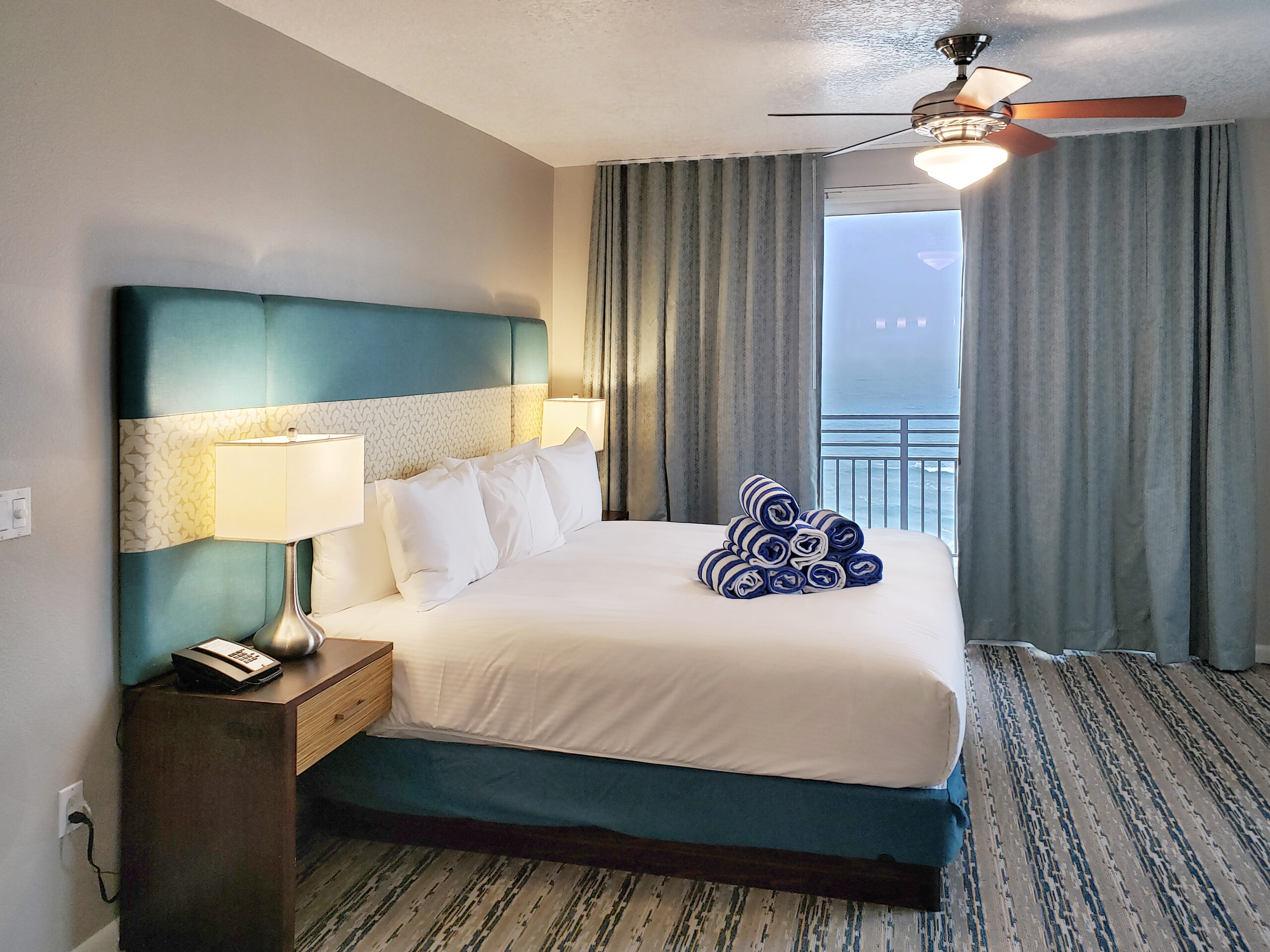 Oceanfront guestroom at Wyndham Ocean Walk with ceiling fan and balcony doors