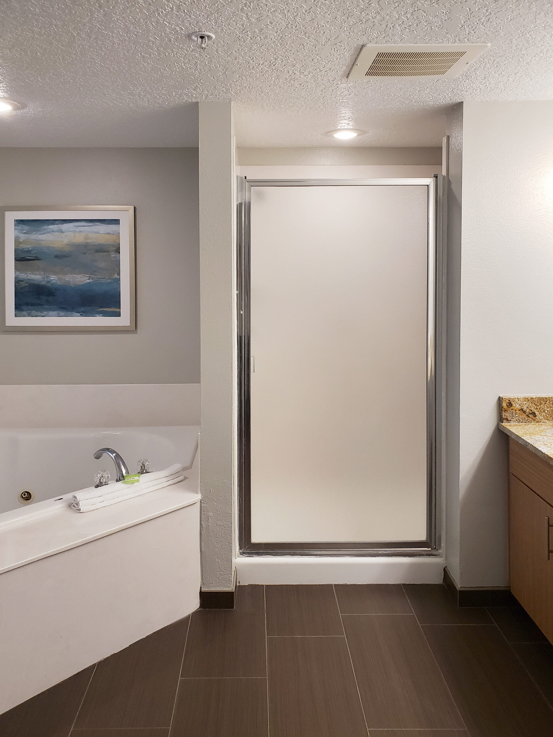 Renovated guest bathroom at Wyndham Ocean Walk with soaking tub and glass shower