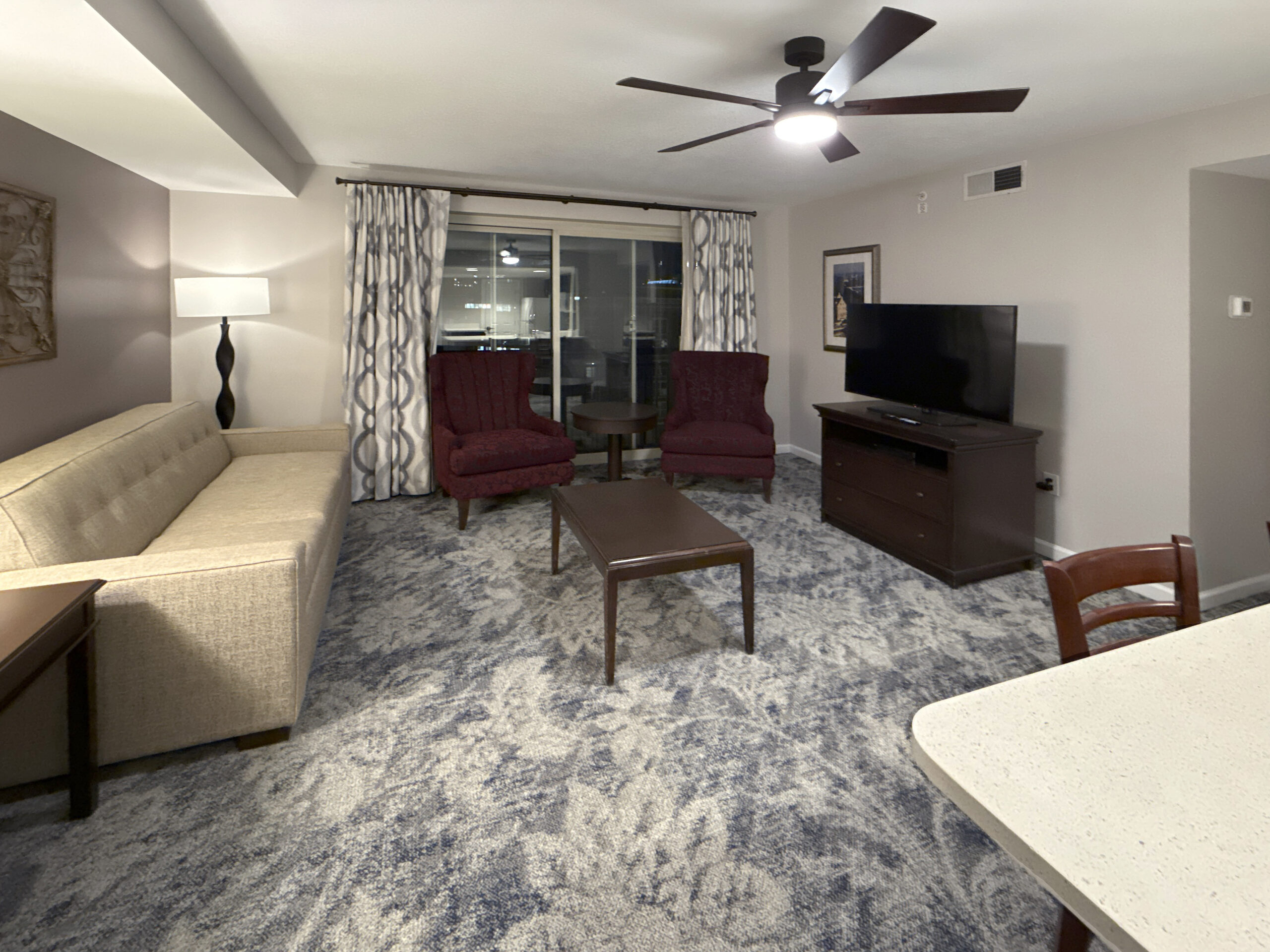 Suite living area at Wyndham Old Town Alexandria with sofa, armchairs and kitchen beyond