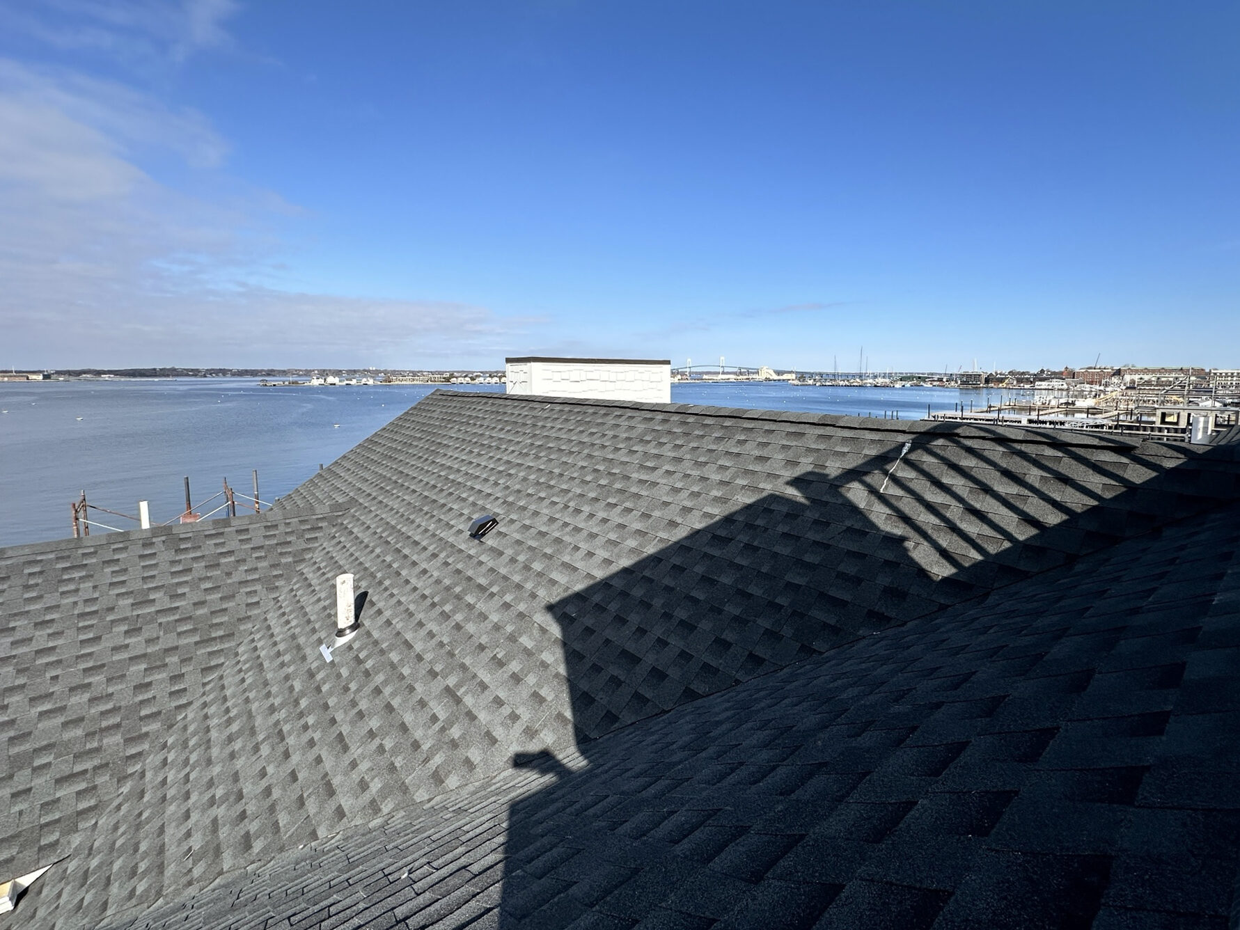 Newly completed roof shingling at Wyndham Onshore Newport with Newport harbour beyond