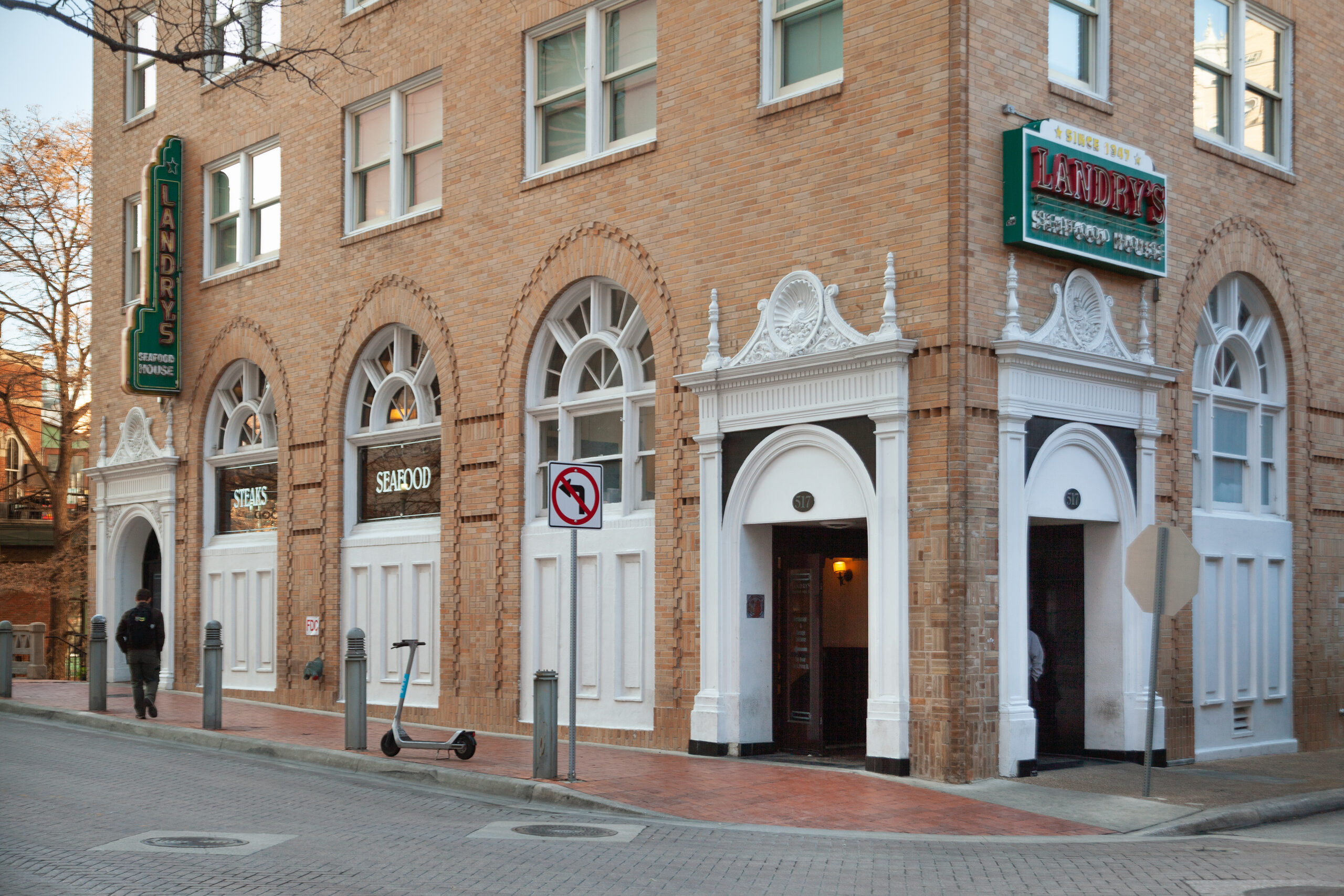 Wyndham Riverside Suites corner elevation on a San Antonio street, arched ground-floor windows