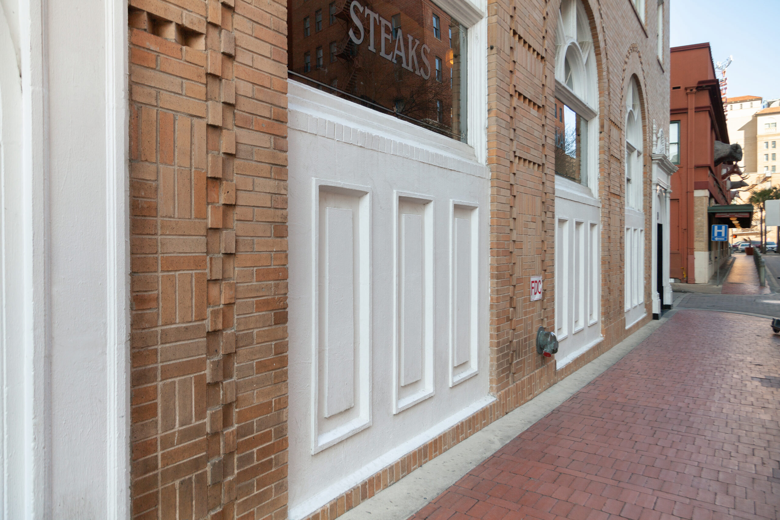 Detail of the restored brick facade and white panelled storefront at Wyndham Riverside Suites