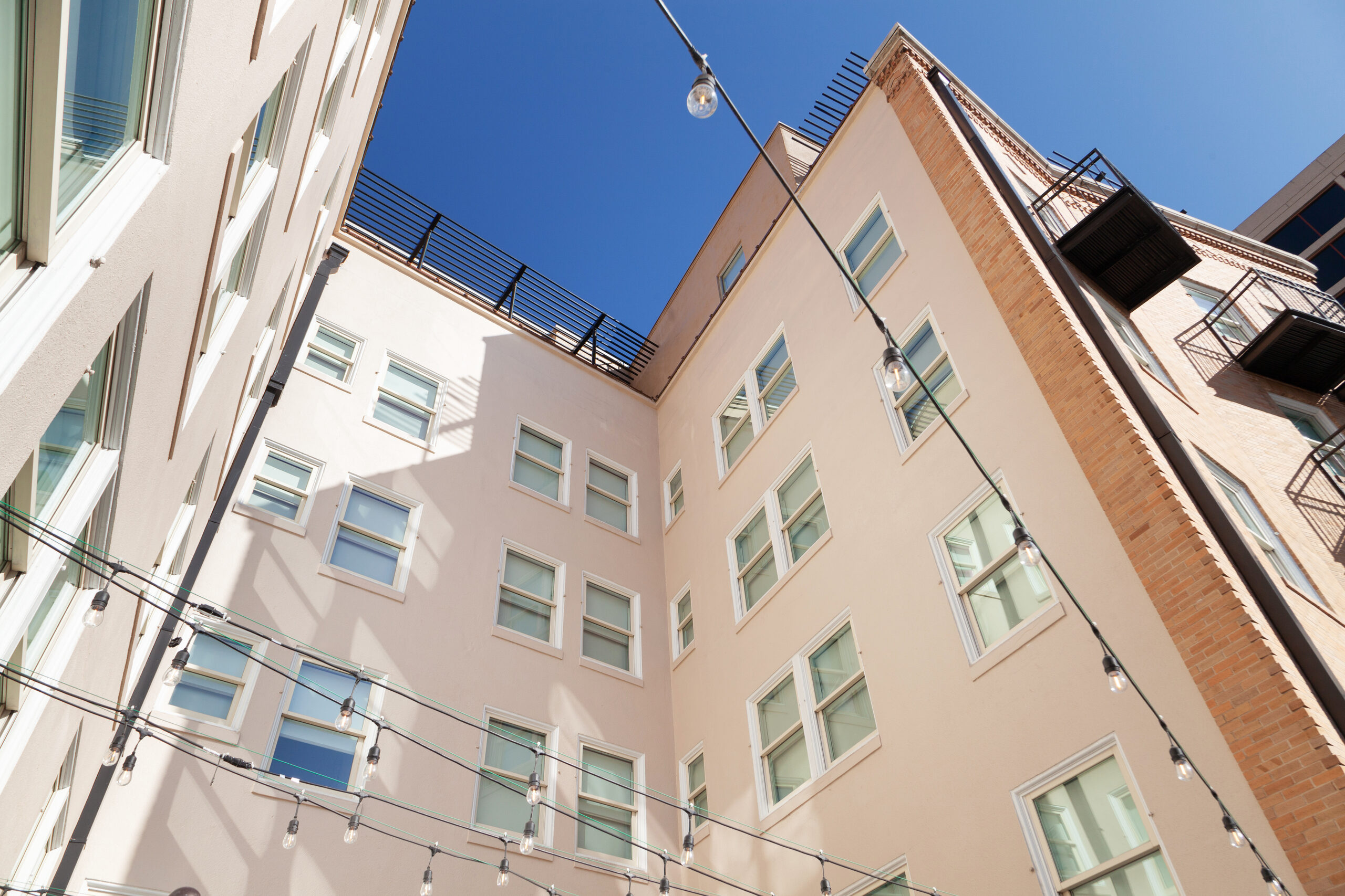 Looking up at the Wyndham Riverside Suites courtyard elevation against a clear sky