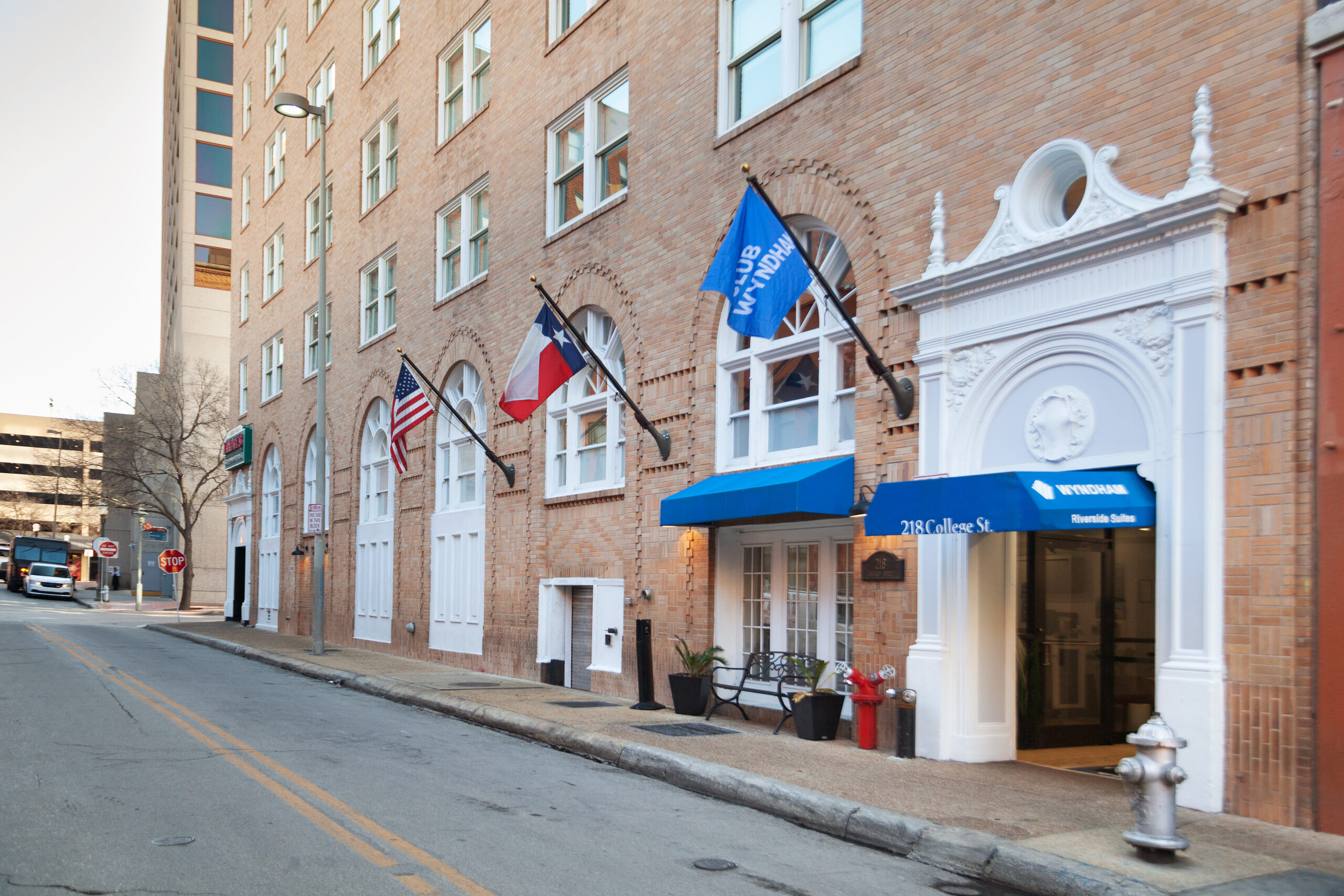 Wyndham Riverside Suites entrance with Wyndham awning and flags above the portico