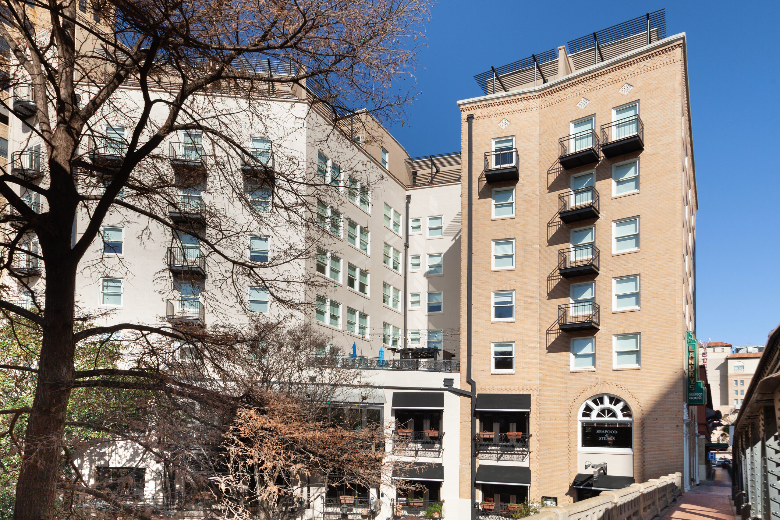 Wyndham Riverside Suites viewed through bare trees from across the street